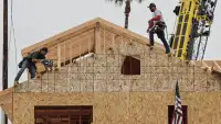 Робітники монтують покрівлю нового будинку в Palm Beach Gardens, Флорида — ілюстративне зображення до новини